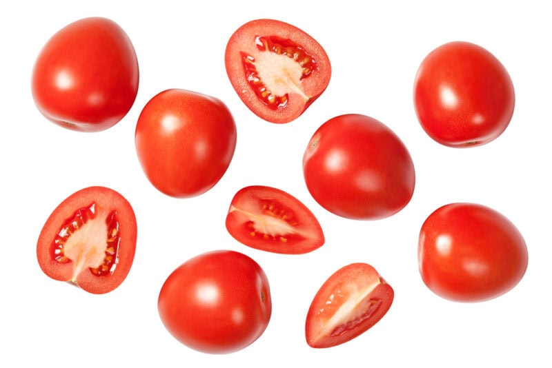Falling plum tomatoes isolated on white background