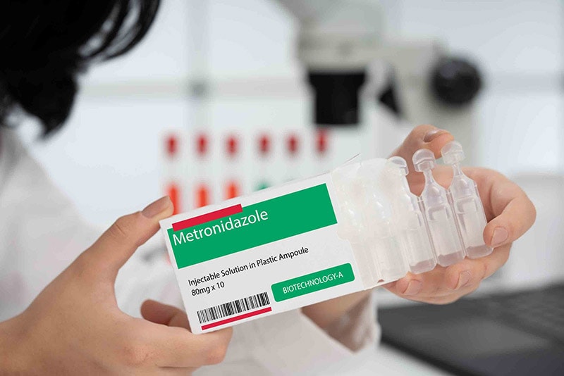 woman holding vials of metronidazole